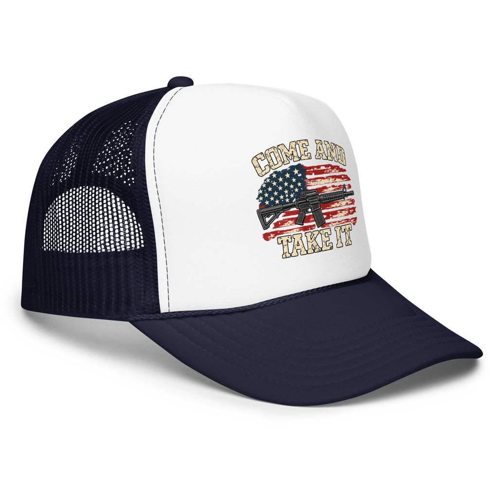 Angled front view of foam trucker hat, white with navy brim and mesh back, with Come and Take It lettering, American flag and rifle artwork
