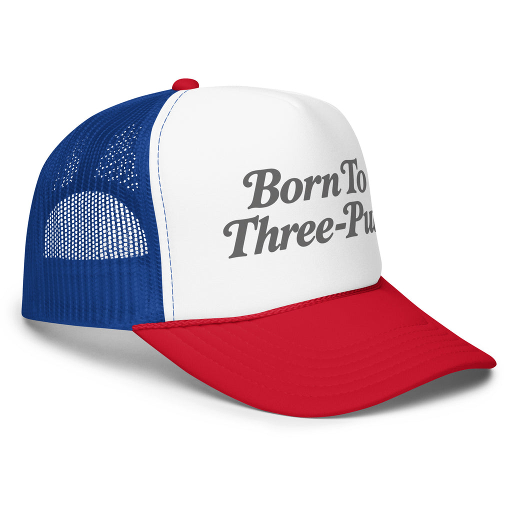 Angled front view of foam trucker hat, white with red brim and royal blue mesh back, featuring Born to Three-Putt script lettering